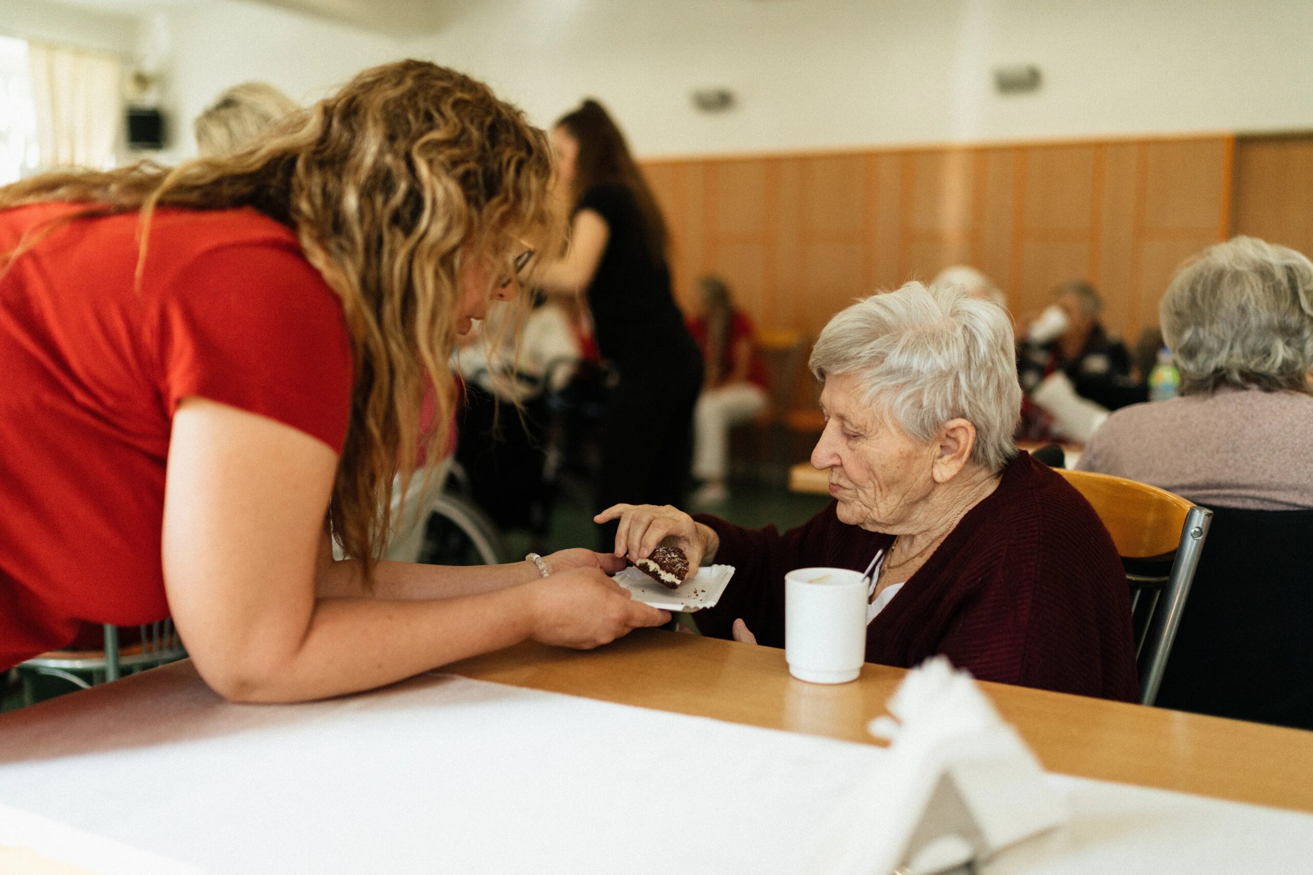 basic dog training commands every dog should know - An elderly woman being assisted by a caregiver in a nursing home setting.