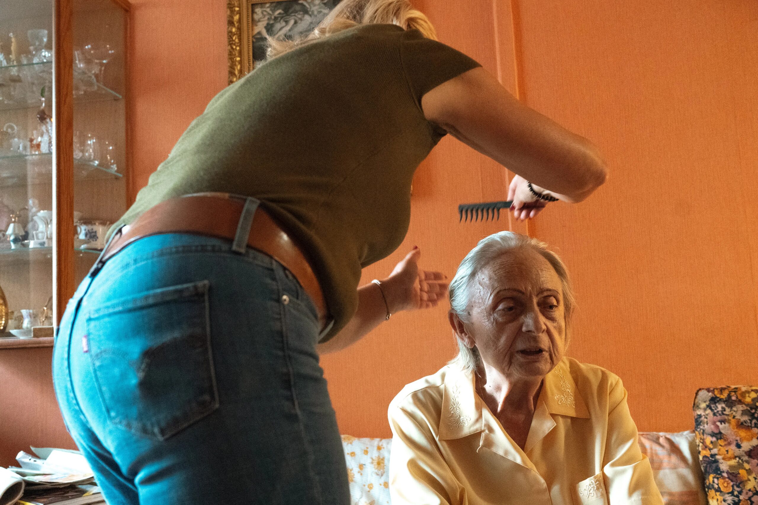 dog separation anxiety solutions for working professionals - A caregiver assisting an elderly woman in grooming at home in Prague.