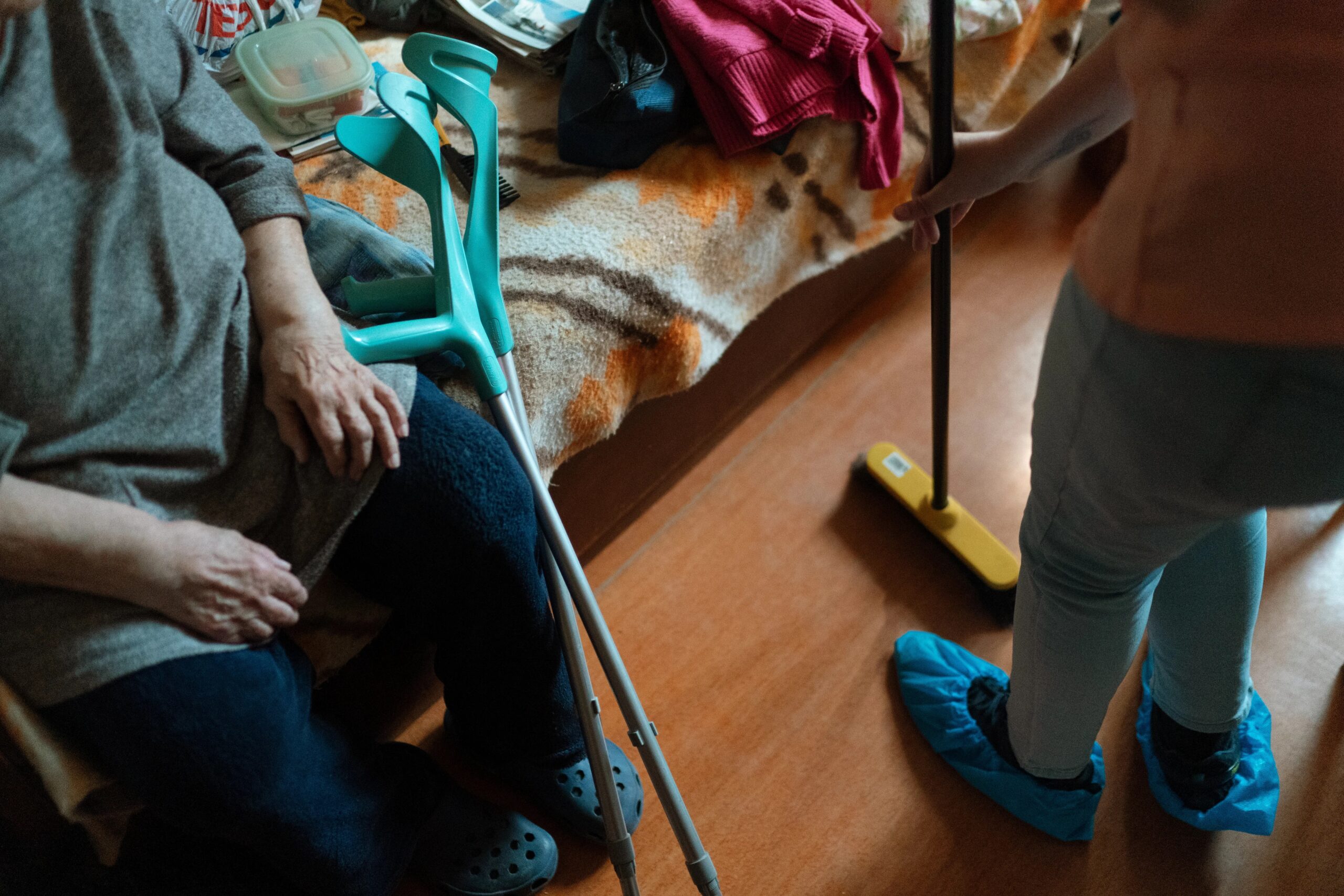 dog grooming tips for busy owners - Caregiver helps an elderly woman with cleaning tasks, showcasing home care support.