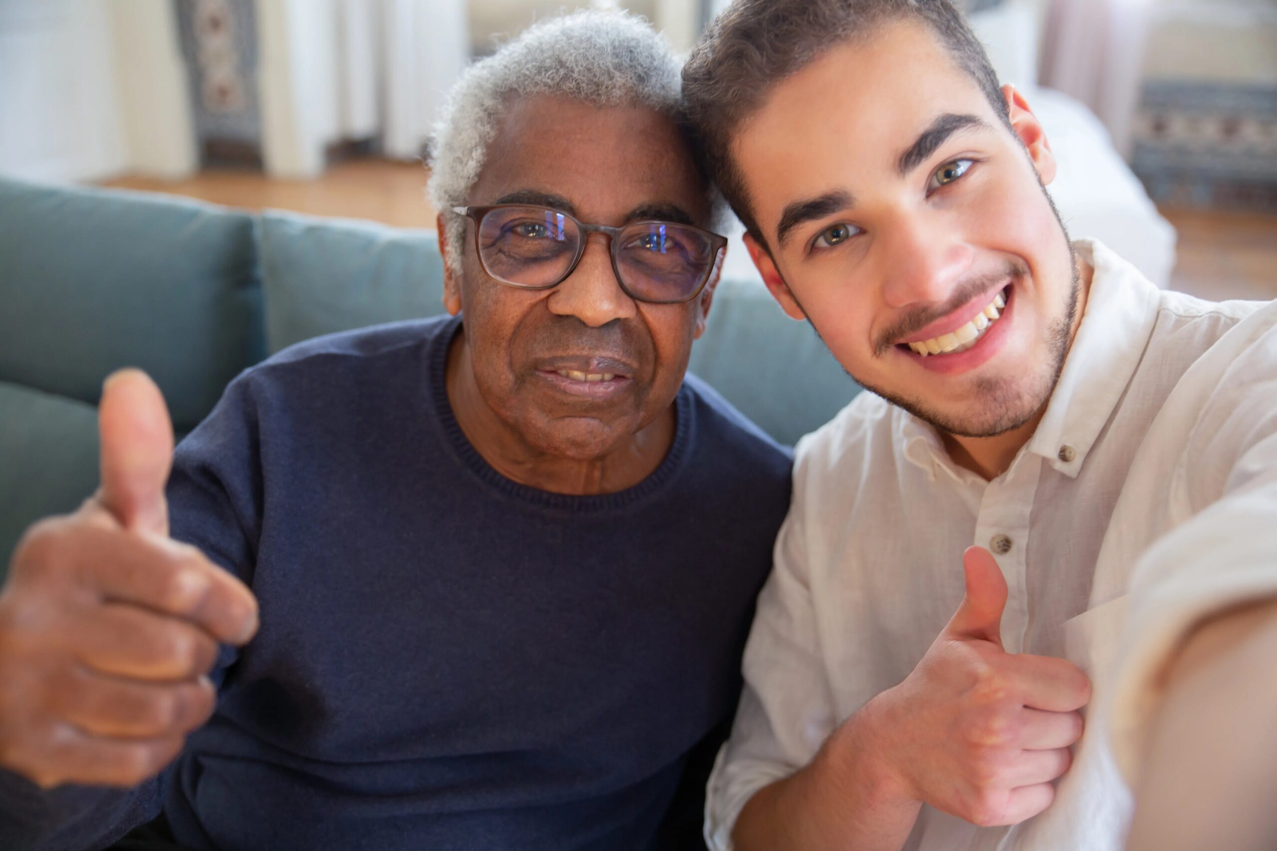 fun activities for dogs while owners are at work - An elderly man and a young man smiling with thumbs up at home, representing friendship and care.